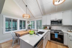 a kitchen with white cabinets and a wooden table at 1412 Dune Loft Villa in Seabrook Island