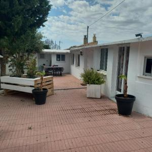 a house with potted plants on a brick patio at Chalet vintage in Moralet