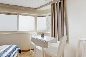 Habitación con escritorio, cama y ventanas. en Atlantis 302, en Ocean City