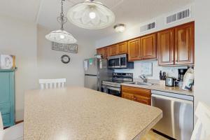 Una cocina con gabinetes de madera y encimera. en Atlantis 302, en Ocean City 13 fotos más