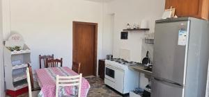a kitchen with a refrigerator and a stove and a table at Stone House Hostel Elbasan in Elbasan