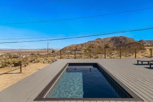 una piscina en una terraza de madera con vistas a la montaña en Burrobrush Terrace, en Joshua Tree