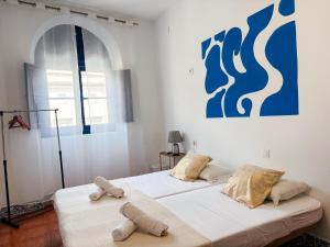 two beds in a white room with towels on them at Rio Hostel in Seville