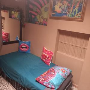 a bedroom with a bed with colorful pillows on it at Chalet vintage in Moralet +11 photos