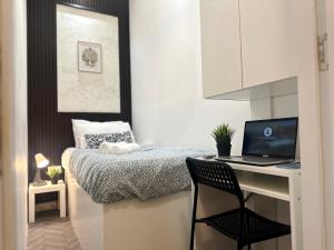 1 dormitorio con escritorio y 1 cama con ordenador portátil en Nomad Nook Room in Tecom Barsha Heights, en Dubái