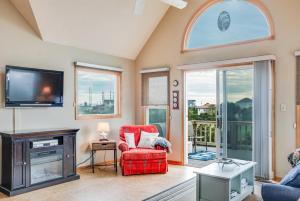 a living room with a tv and a red chair at Baymeadow 10 in Nags Head