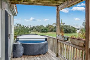 a hot tub sitting on a porch with a view at Baymeadow 10 in Nags Head