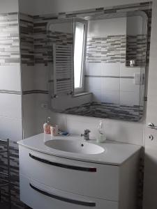 a bathroom with a white sink and a mirror at Il Tuffatore in Capaccio-Paestum +10 photos