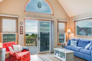 a living room with two couches and a balcony at Baymeadow 10 in Nags Head