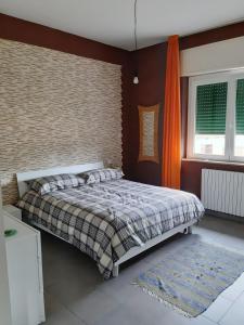a bedroom with a bed and an orange curtain at Il Tuffatore in Capaccio-Paestum