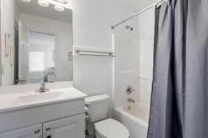 Un baño blanco con lavabo e inodoro. en Beach Bound, en Southern Shores 38 fotos más