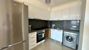 a kitchen with a stainless steel refrigerator and a dishwasher at Two Bedrooms LongBeach SeaView Escape in Paralimni +2 photos