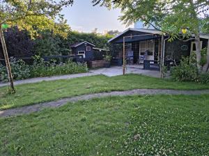 a yard with a house with a patio at 't klompenkot in Middelburg