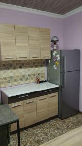 a kitchen with a stainless steel refrigerator and wooden cabinets at Barateli in Kutaisi
