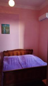 a bedroom with a bed with a purple blanket at Barateli in Kutaisi