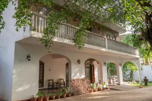 卡图纳耶克Murphy's Transit Villa Airport Pick & Drop Katunayake的带阳台的白色建筑,部分植物