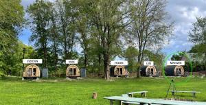 a group of huts in a field with a picnic table at Gościn nad Drawą Glamping in Drawno +43 photos