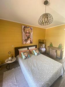 a bedroom with a bed with a portrait of a woman at Studio zen piscine in Balaruc-les-Bains +21 photos