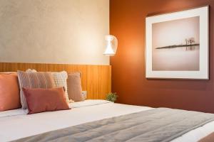 a bedroom with a bed with a picture on the wall at TW Cyclinn Vila Olimpia in São Paulo