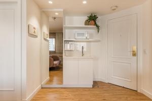 a white kitchen with a sink and a microwave at TW Cyclinn Vila Olimpia in São Paulo
