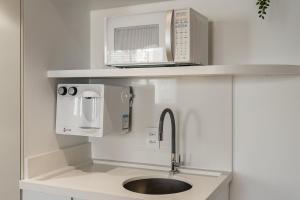 a kitchen with a sink and a microwave at TW Cyclinn Vila Olimpia in São Paulo