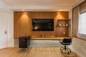 a room with a desk with a television and a chair at TW Cyclinn Vila Olimpia in São Paulo