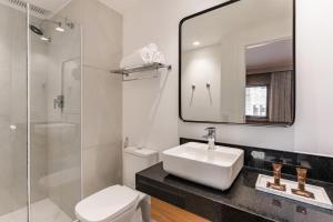 a bathroom with a sink and a toilet and a mirror at TW Cyclinn Vila Olimpia in São Paulo