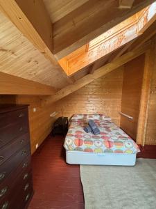 a bedroom with a bed in a wooden attic at Casa rural 'La Huerta' in Rascafría