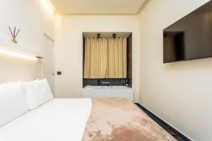 a white bedroom with a bed and a sink at Marina Home - luxury apartament nel cuore di Catania in Catania
