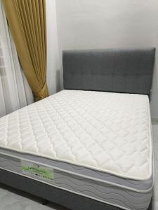 a mattress sitting next to a bed with a curtain at ZIYA Homestay in Jertih