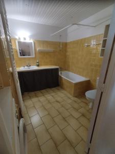 a bathroom with a tub and a sink and a toilet at Appartement 5 pax à la ferme - Risoul village in Risoul