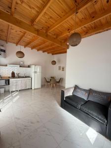 a living room with a black couch and a kitchen at Maschwitz Norte C in Ingeniero Maschwitz +2 photos