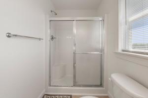 a white bathroom with a shower and a toilet at Casa Sirena in Southern Shores +25 photos