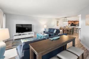 Una sala de estar con un sofá azul y una mesa. en Heron Cove, en Nags Head