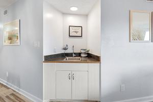 Una cocina blanca con un fregadero en una habitación. en Heron Cove, en Nags Head