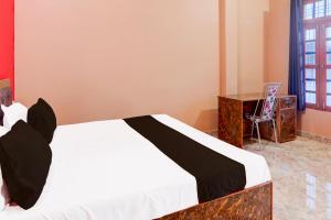 a bedroom with a bed and a desk in a room at Hotel O Kashvi Hotel in Misrikh +21 photos