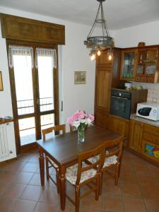 une cuisine avec une table en bois et des fleurs. dans l'établissement Casa Bellavista, à Civenna