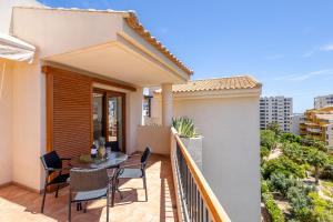 a balcony of a house with a table and chairs at Apartment Holiday Haven in Punta Prima +21 photos