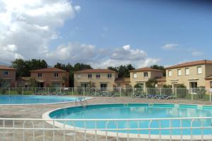 una gran piscina con edificios en el fondo en Chez Twin&Twin, en Santa-Maria-Poggio