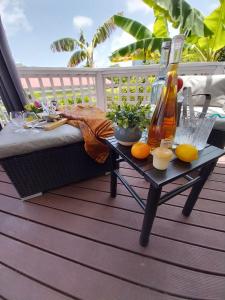 a table with drinks and oranges on a deck at 2 Bedroom Dream Cottage-Point Blanche in Philipsburg