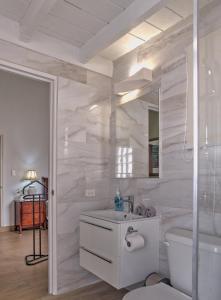 a white bathroom with a sink and a toilet at 2 Bedroom Dream Cottage-Point Blanche in Philipsburg