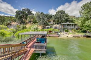 ein Haus am Fluss mit einem Boot im Wasser in der Unterkunft Clear Lake Getaway with Dock Access and Shared Yard! in Clearlake Oaks