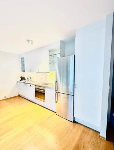 an empty kitchen with a stainless steel refrigerator at Tjuvholmen apartment 2BR in Oslo