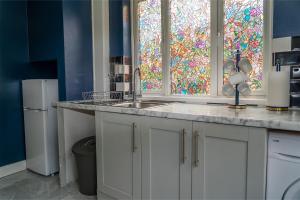 una cucina con lavandino e una vetrata colorata di Games Room free Parking House a Bristol Altre 55 foto