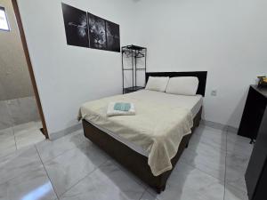 アパレシダ・デ・ゴイアニアにあるFlat completo a 24 minutos do Flamboyant Shoppingの白い部屋にあるベッドのある寝室