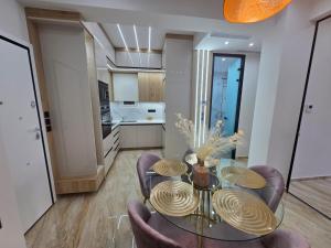 a dining room with a table and chairs and a kitchen at AGORA luxury APARTMENT 2 in Loutraki
