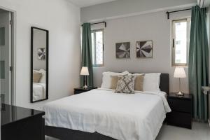 a bedroom with a white bed and two windows at JR 7 Suites by Yellowkey in Santo Domingo +17 photos