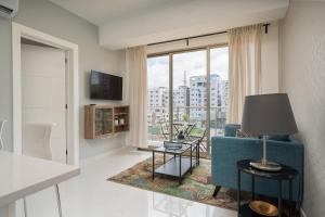 a living room with a blue couch and a large window at JR 7 Suites by Yellowkey in Santo Domingo