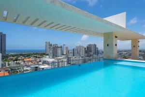 a swimming pool on top of a building with a city at JR 7 Suites by Yellowkey in Santo Domingo