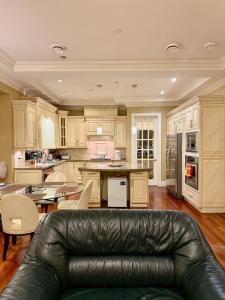 a living room with a leather couch in a kitchen at Peaceful Retreat in Arbutus in Vancouver
